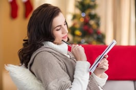 Brunette lying on the couch thinking about her christmas list at home in the living room