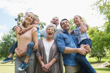 Portrait of cheerful extended family standing at the park